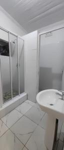 a white bathroom with a sink and a shower at Halford Backpackers, Durban in Durban +23 photos