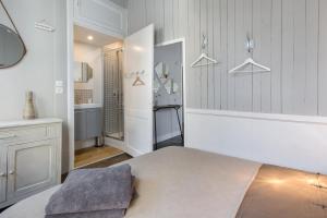 a white room with a bed and a bathroom at Ty Sauveur by Cocoonr in Rennes
