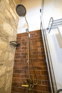 a shower in a bathroom with a brick wall at Atrium Suites Taş Konak in Urla +61 photos