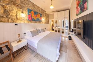 a bedroom with a large bed and a stone wall at Atrium Suites Taş Konak in Urla