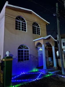 a house with blue and green lights in front of it at Bridgeview Arcadia Three in Portmore