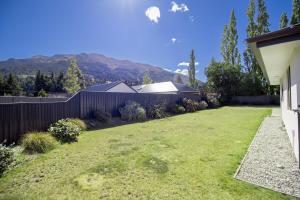 a backyard with a fence and a grass yard at Hāwea Home Haven in Lake Hāwea