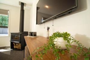 a living room with a wooden table and a stove at Hāwea Home Haven in Lake Hāwea