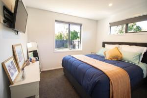a bedroom with a bed and a tv on a wall at Hāwea Home Haven in Lake Hāwea