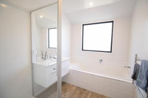 a white bathroom with a tub and a sink at Hāwea Home Haven in Lake Hāwea +9 photos