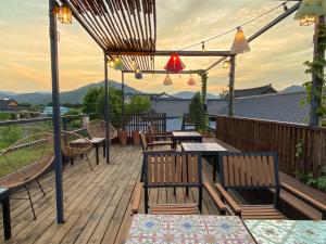 a deck with tables and chairs on a roof at Architect's Cat Hanok - Sindal House Gyeongju in Gyeongju