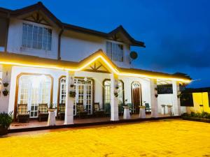 a white house with a lot of windows at Shellys Cottage Nuwara Eliya in Nuwara Eliya