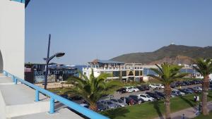 a view of a parking lot with palm trees and a building at Appartement B-23 Cabo Négro in Cabo Negro