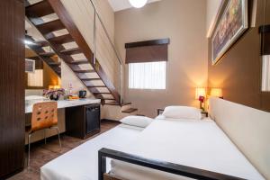 ein Zimmer mit zwei Betten und einer Treppe in der Unterkunft Favor Hotel Makassar City Center By LIFE in Makassar + 17 Fotos
