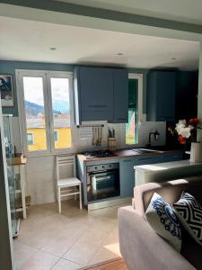 a kitchen with blue cabinets and a stove top oven at Nel blu dipinto di blu Apartment in Levanto