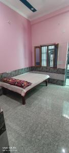 a bedroom with a bed in the corner of a room at RK Residency in Ayodhya