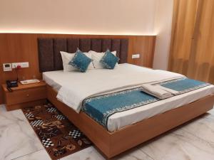 a bedroom with a large bed with blue pillows at RK Residency in Ayodhya