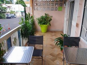 a balcony with chairs and a table and plants at Auberge de l'hippocampe in Moroni