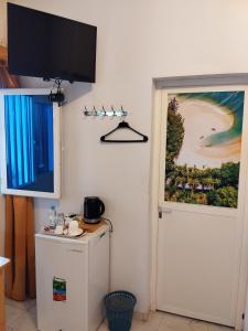 a room with a refrigerator and a flat screen tv at Auberge de l'hippocampe in Moroni
