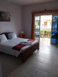 a bedroom with a bed and a sliding glass door at Auberge de l'hippocampe in Moroni