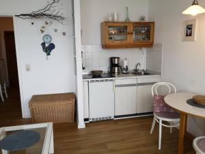 a small kitchen with a counter and a table at Strandhotel App. 63 in Dahme