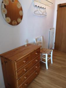a wooden dresser with a mirror and a table and chairs at Strandhotel App. 63 in Dahme
