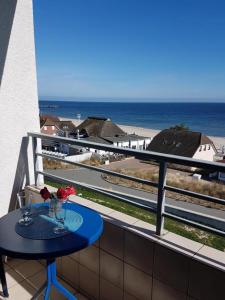 a table on a balcony with a view of the beach at Strandhotel App. 63 in Dahme