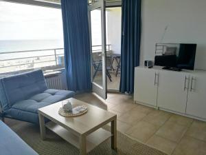 a living room with a couch and a tv and a table at Strandhotel Wohnung 48 in Dahme