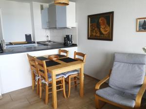 a kitchen with a table and chairs in a kitchen at Strandhotel Wohnung 48 in Dahme