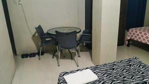 a room with a table and chairs and a bed at RnR Suites in Caranglaan