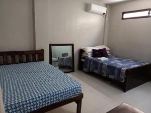 a bedroom with two beds and a mirror at RnR Suites in Caranglaan