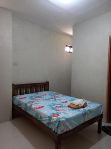 a bedroom with a bed with a blue comforter at RnR Suites in Caranglaan