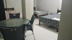a room with a table and chairs and a bed at RnR Suites in Caranglaan