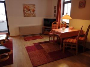 a living room with a table and a television at Lindenhof Wohnung 19 in Dahme