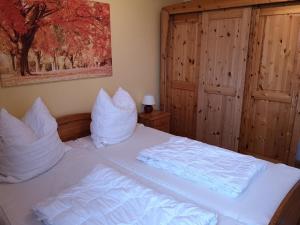 a bedroom with a bed with white sheets and pillows at Lindenhof Wohnung 19 in Dahme