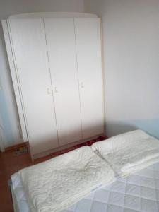 a bed in a room with two large white cabinets at Strandhotel Wohnung 24 in Dahme +10 photos