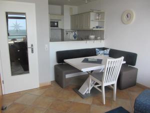 a kitchen and dining room with a table and a chair at Strandhotel Wohnung 28 in Dahme
