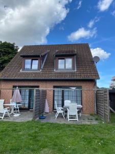 a brick house with chairs and tables in the yard at Saarstrasse 18h in Dahme