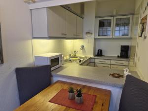 a kitchen with a wooden table and a microwave at Strandhotel Wohnung 2 in Dahme