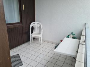 a white chair sitting in a room at Strandhotel Wohnung 2 in Dahme +8 photos