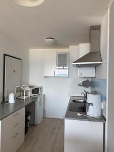 a kitchen with white cabinets and a counter top at Strandhotel Wohnung 68 in Dahme