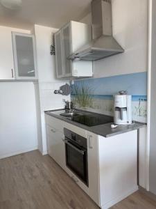 a small kitchen with a sink and a stove at Strandhotel Wohnung 68 in Dahme +11 photos