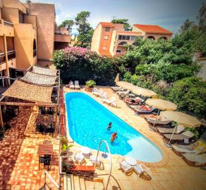an overhead view of a swimming pool with chairs and umbrellas at Hôtel Le Maritime in Argelès-sur-Mer