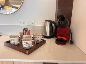 a counter with three coffee mugs and a kettle at Bang Kao Beachfront Villa in Nathon Bay