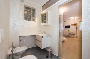 Casa Matteotti في روفينج: حمام أبيض مع حوض ومرحاض