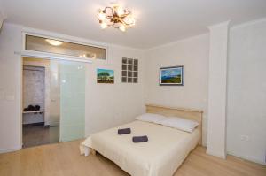 a white bedroom with a bed and a chandelier at Casa Matteotti in Rovinj