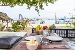 a table with plates of food on top of a balcony at Bang Kao Beachfront Villa in Nathon Bay