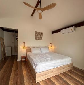 a bedroom with a bed and a ceiling fan at Bang Kao Beachfront Villa in Nathon Bay