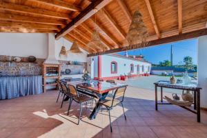 an outdoor kitchen with a table and chairs on a patio at Casa do Arlindo in São Bartolomeu de Messines