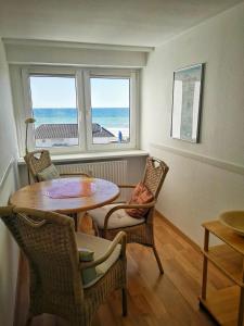 a dining room with a table and chairs and the ocean at Strandhotel 27 in Dahme