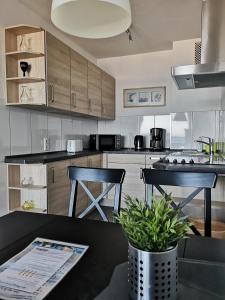 a kitchen with a table and two stools in it at Strandhotel Wohnung 42 in Dahme