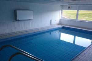 a large swimming pool with a screen on the wall at Strandhotel Wohnung 42 in Dahme +8 photos