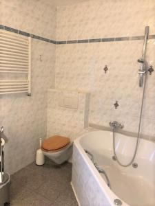 a bathroom with a toilet and a bath tub at Memelstrasse 6 in Dahme +19 photos