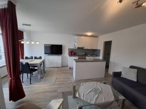 a living room with a couch and a table and a kitchen at Strandhotel Wohnung 4 in Dahme