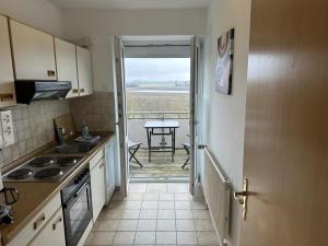 a kitchen with a door open to a table with a view at Fehmarn 17-1 in Fehmarn +4 photos